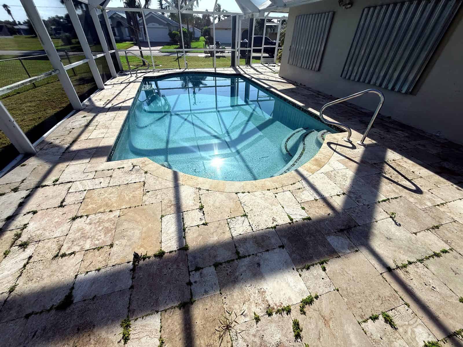 Travertine deck overrun with weeds