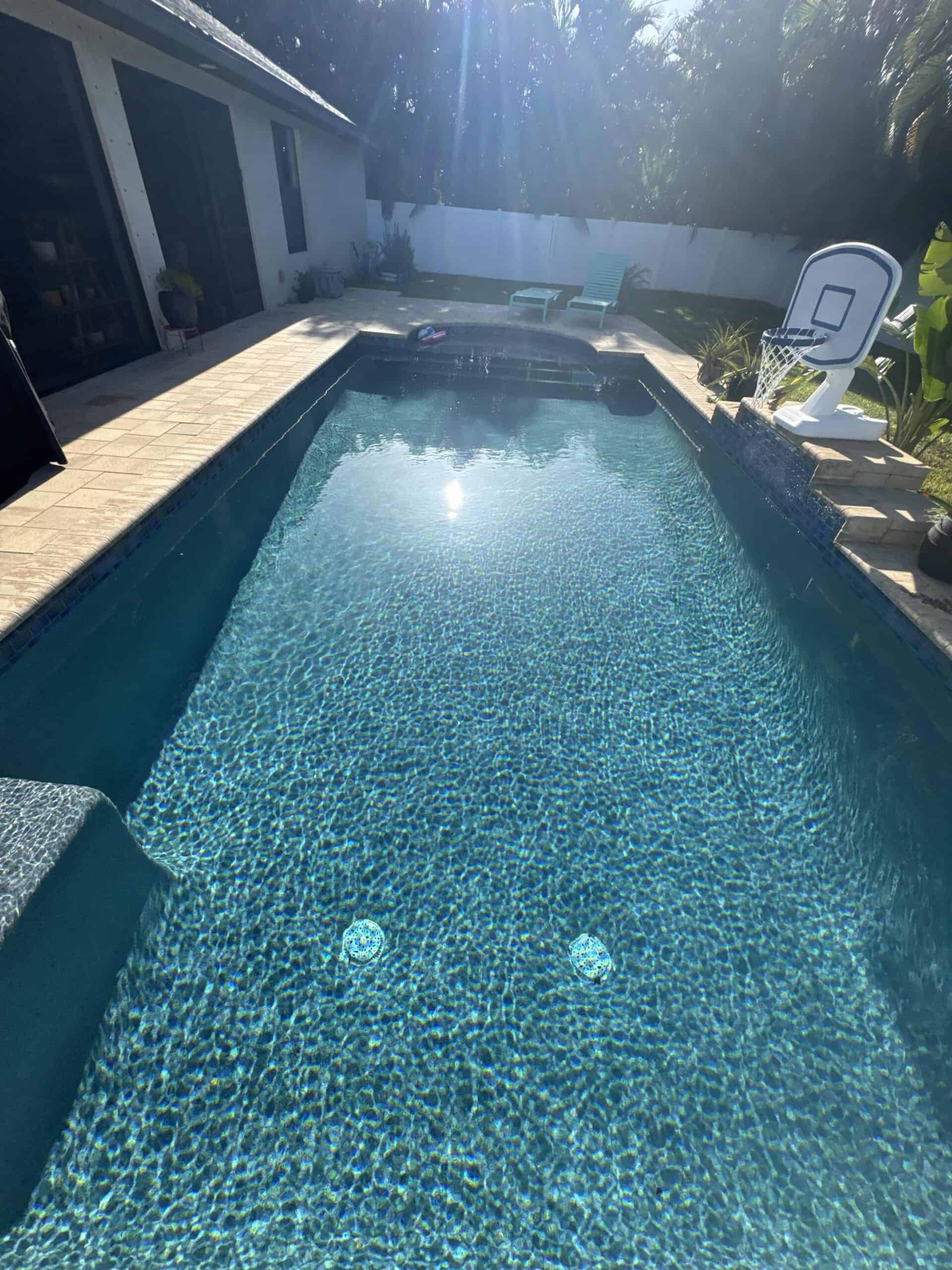 Clear residential pool with clean water and screened enclosure